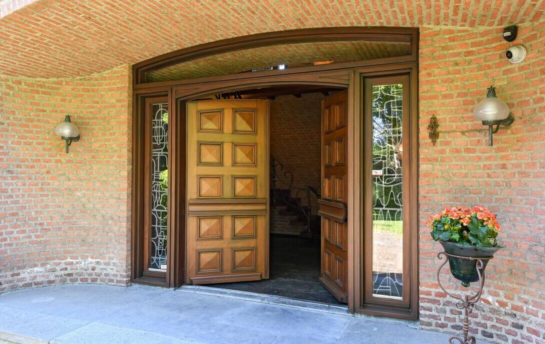 Overdekte entree met dubbele houten deuren